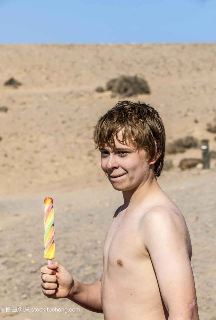 暑假可爱的青少年在沙滩上吃冰淇淋