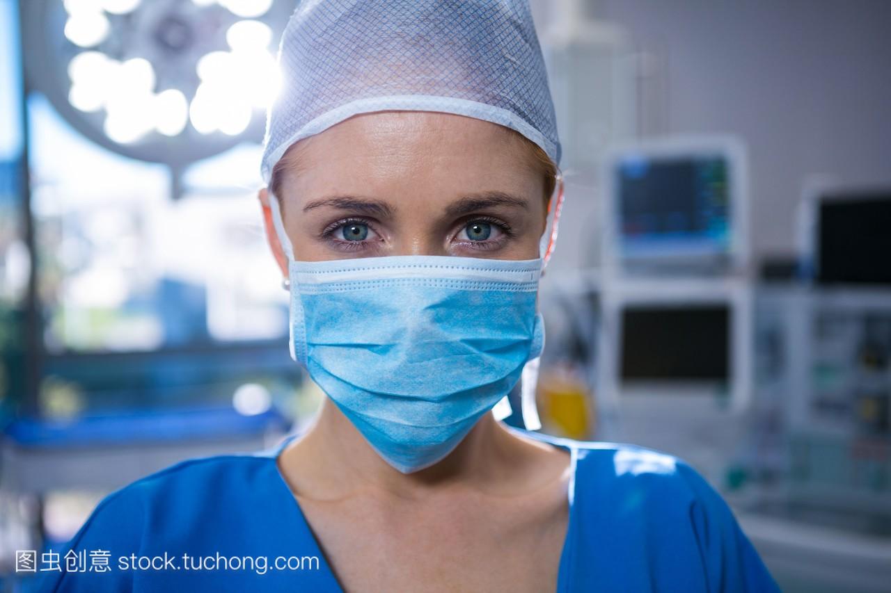 女外科医生在手术室佩戴外科口罩的肖像