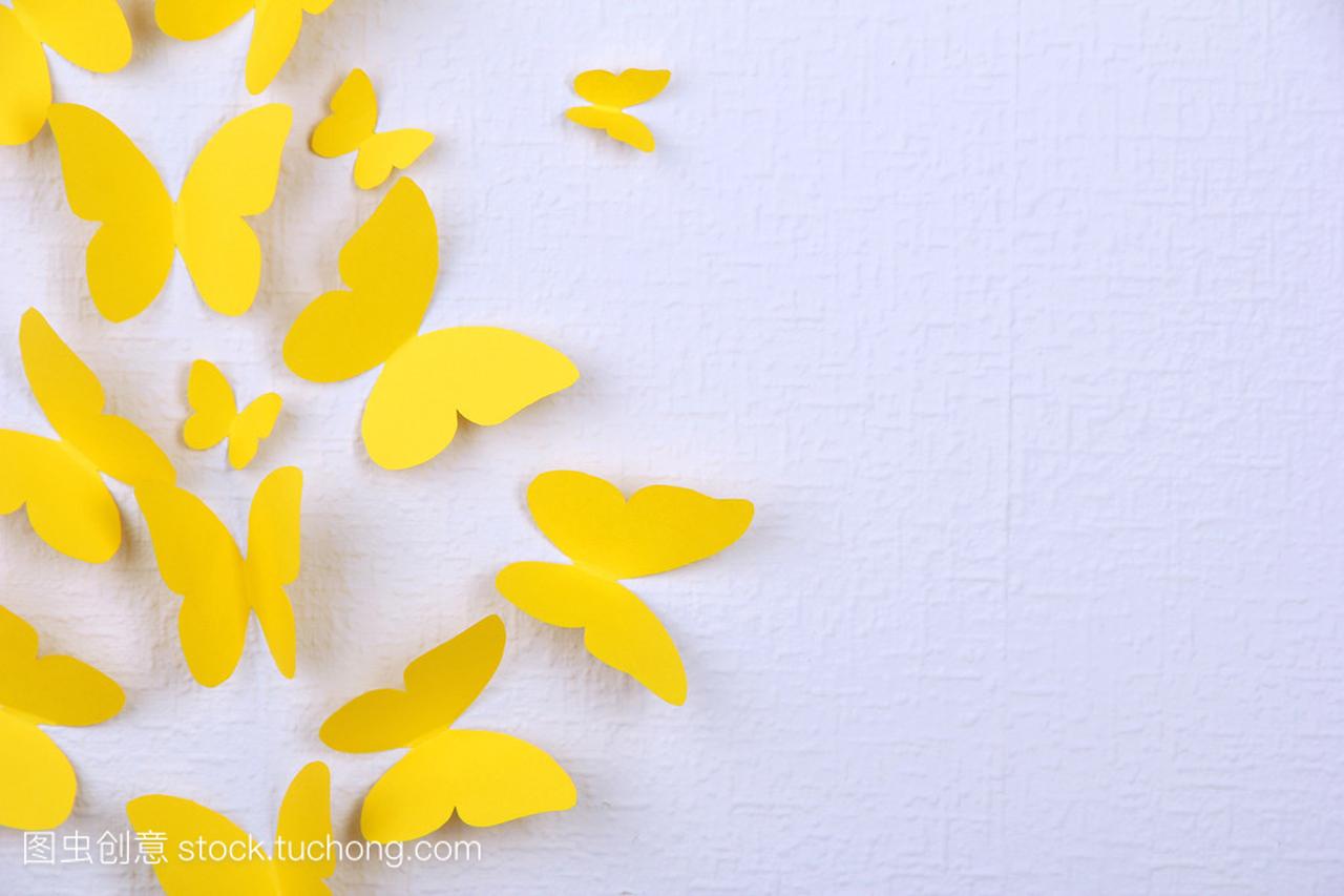 黄色的纸蝴蝶飞向不同的方向在墙上