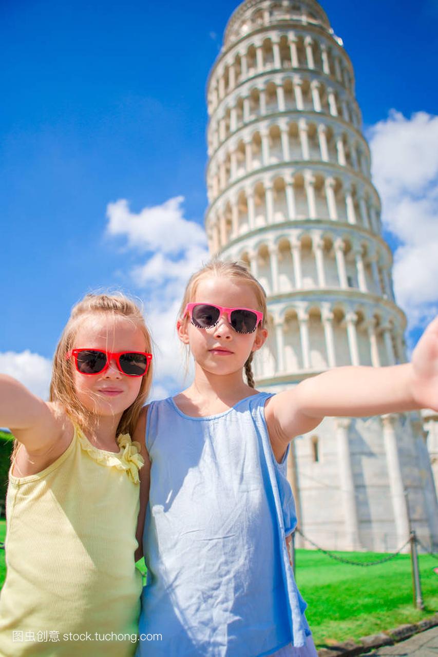 小可爱女孩采取自拍照背景在意大利比萨斜塔。