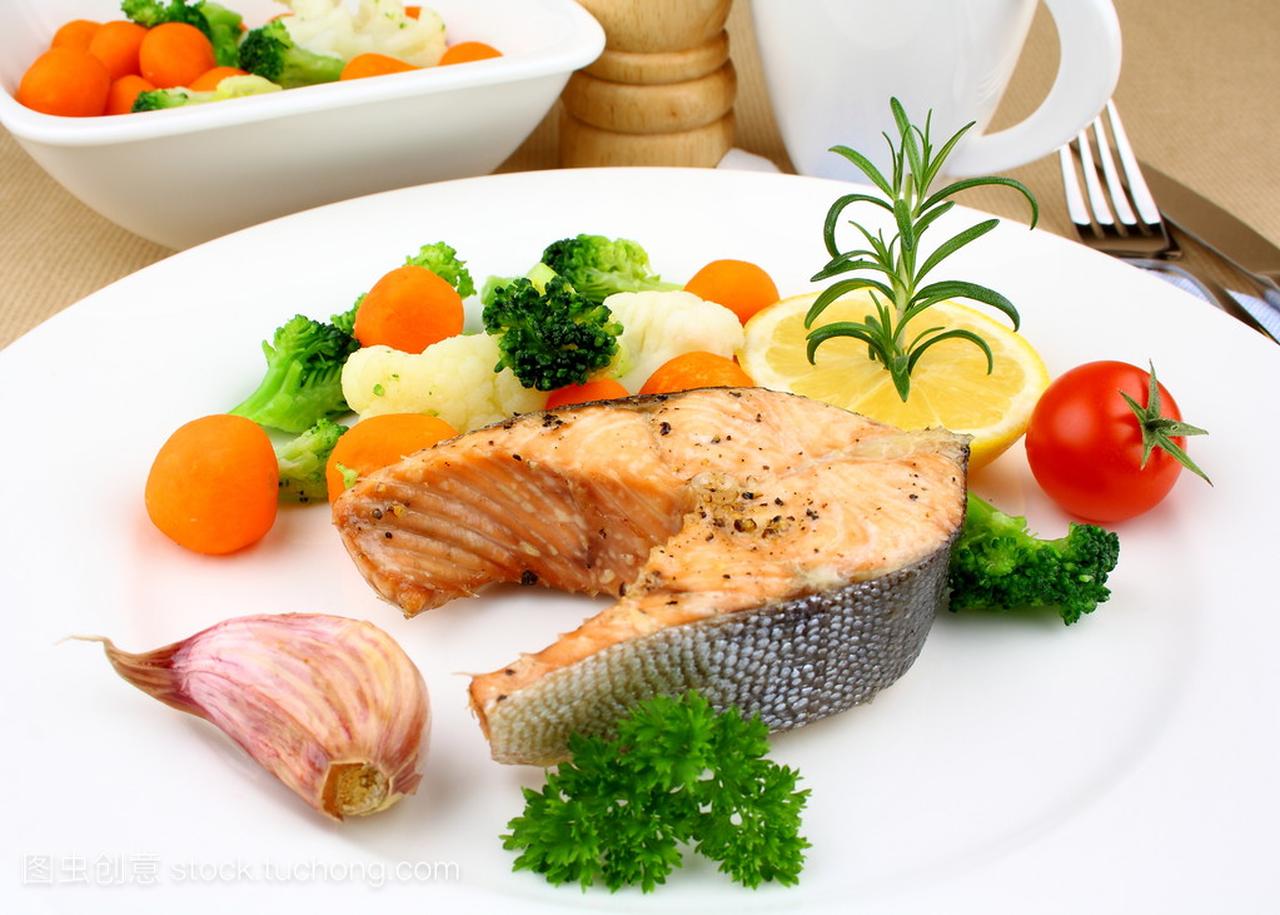 烤三文鱼牛排配蔬菜在白板上