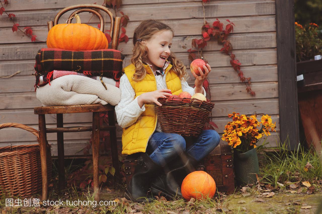 快乐的孩子女孩在农场摘新鲜的苹果。国家生活