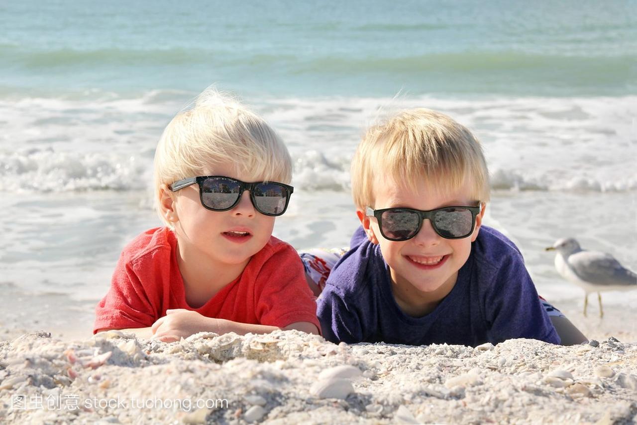 快乐的年轻孩子们躺在沙滩上晒太阳