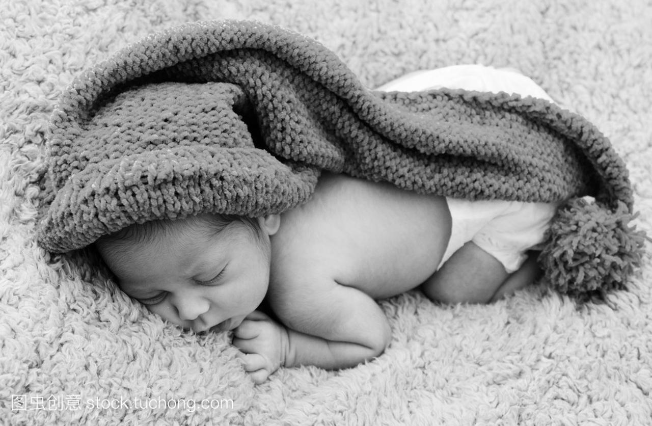 刚出生的婴儿是戴着一顶蓝帽子和放下睡觉