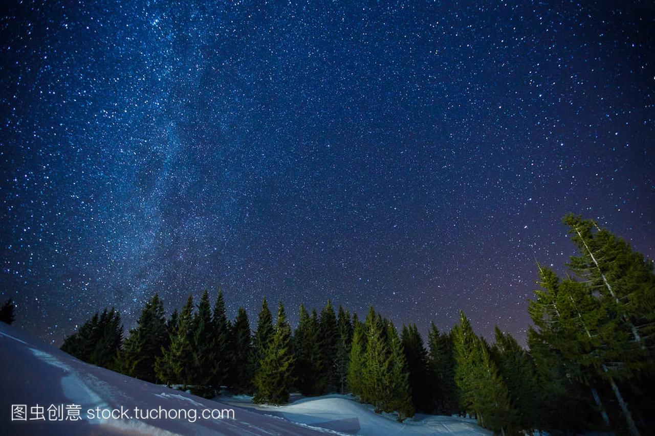 美丽风景的冬季星空夜空之上松林,长时间曝光