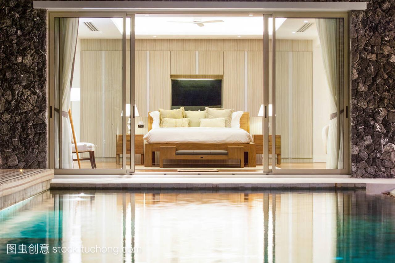 豪华的内饰设计在泳池别墅与舒适的国王的卧室