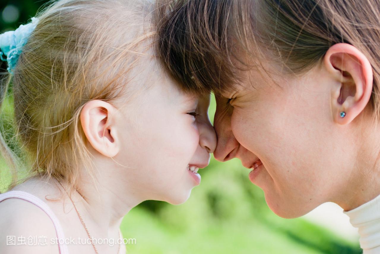 母亲和女儿拥抱对方与自己的鼻子