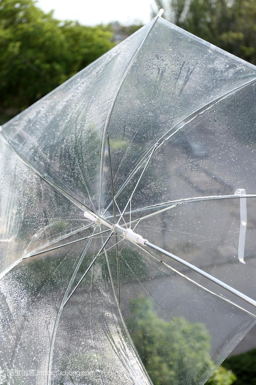 对自然背景下的湿透明雨伞