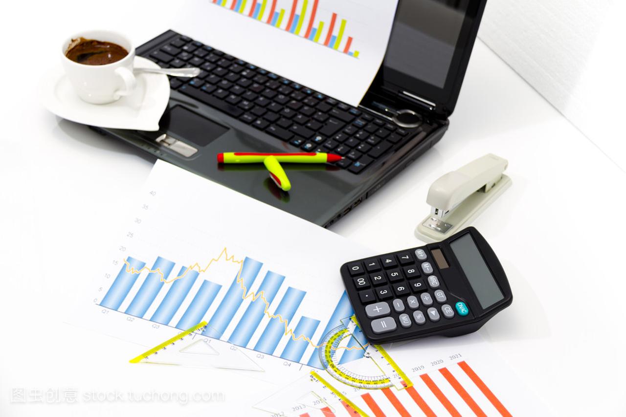 分析业务投资图表与计算器和笔记本电脑