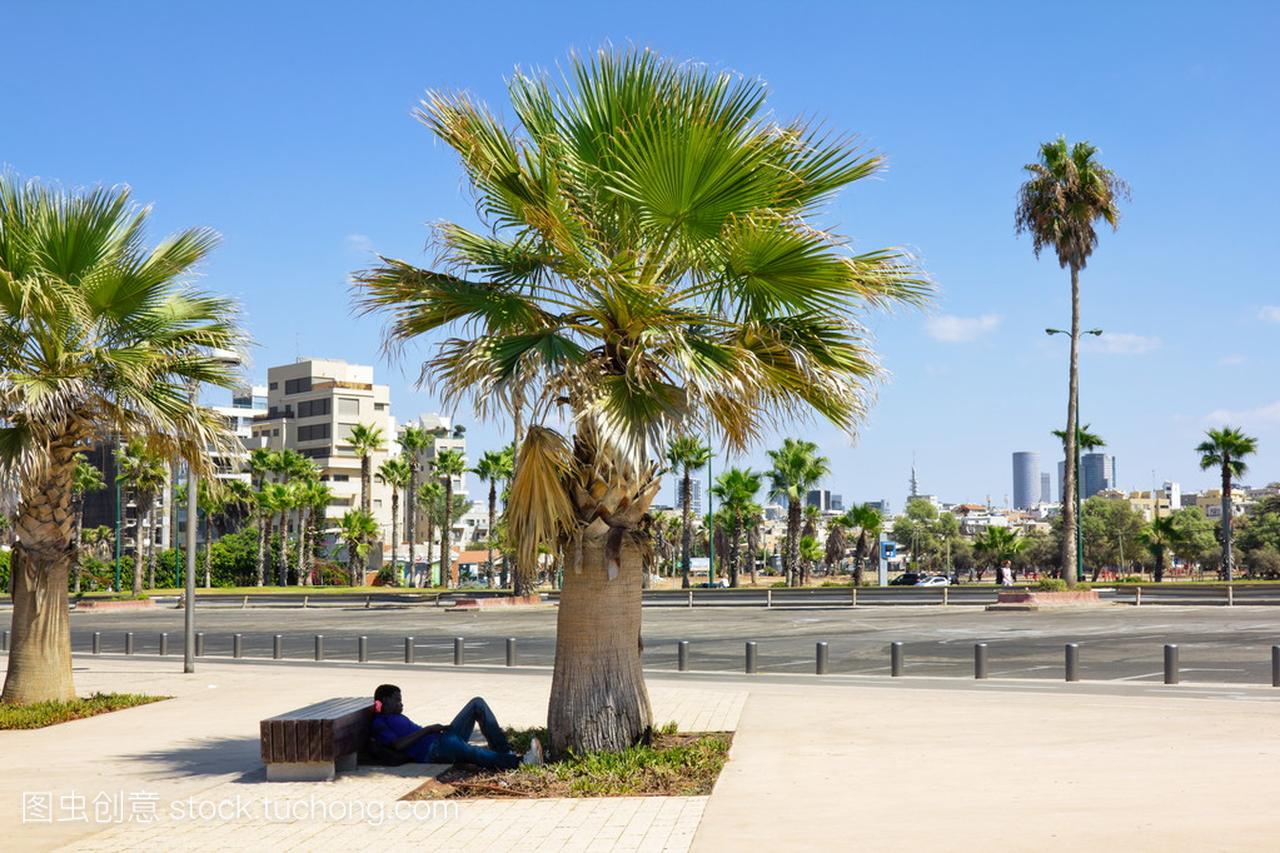 名男子在电话在以色列的特拉维夫海滨长廊上的