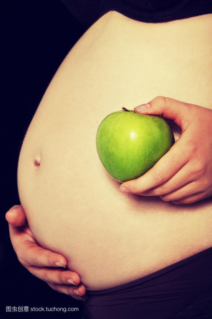 青苹果的孕妇的肚子上