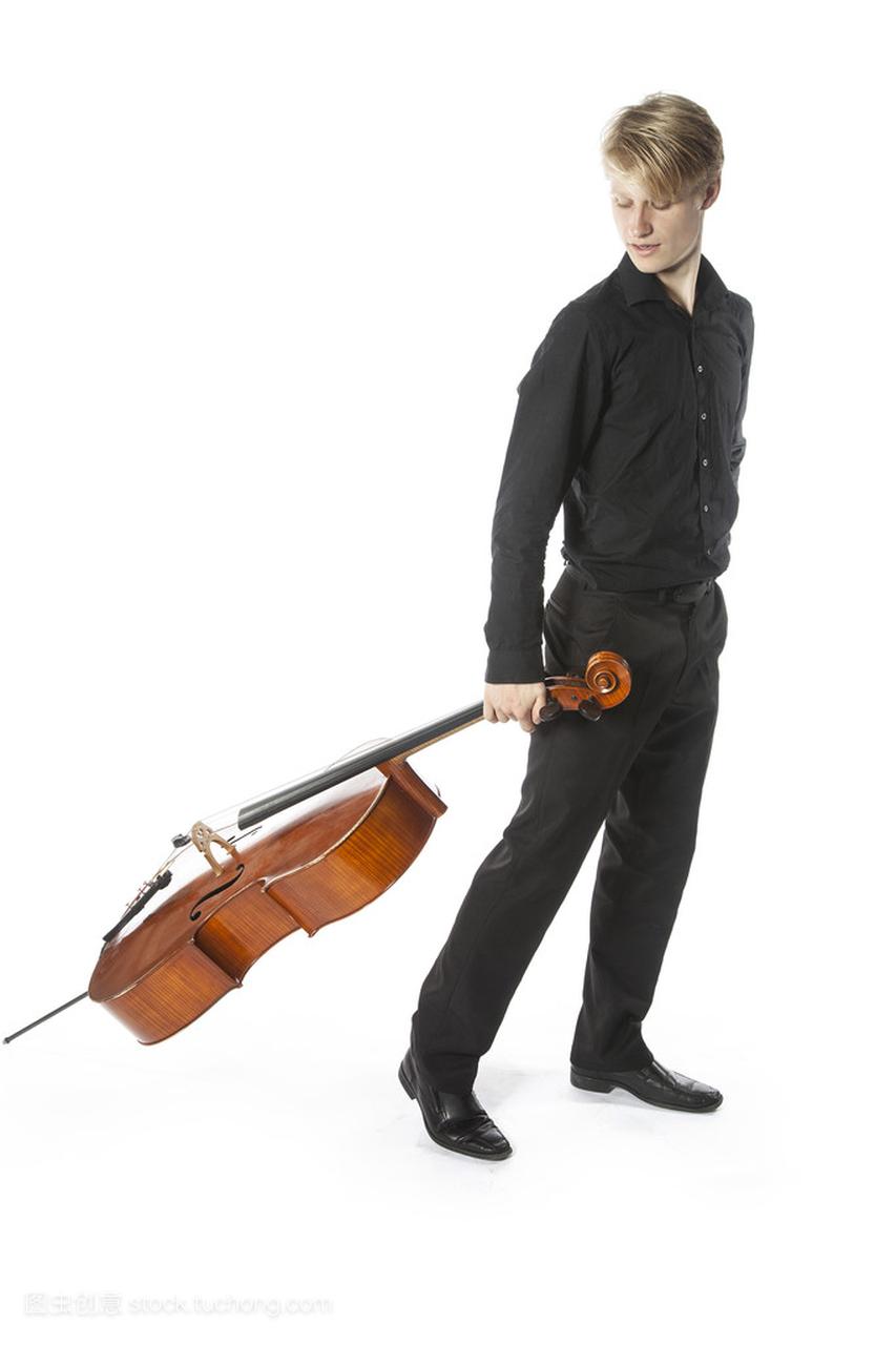 年轻的金发白种男人拖动大提琴在工作室针对白