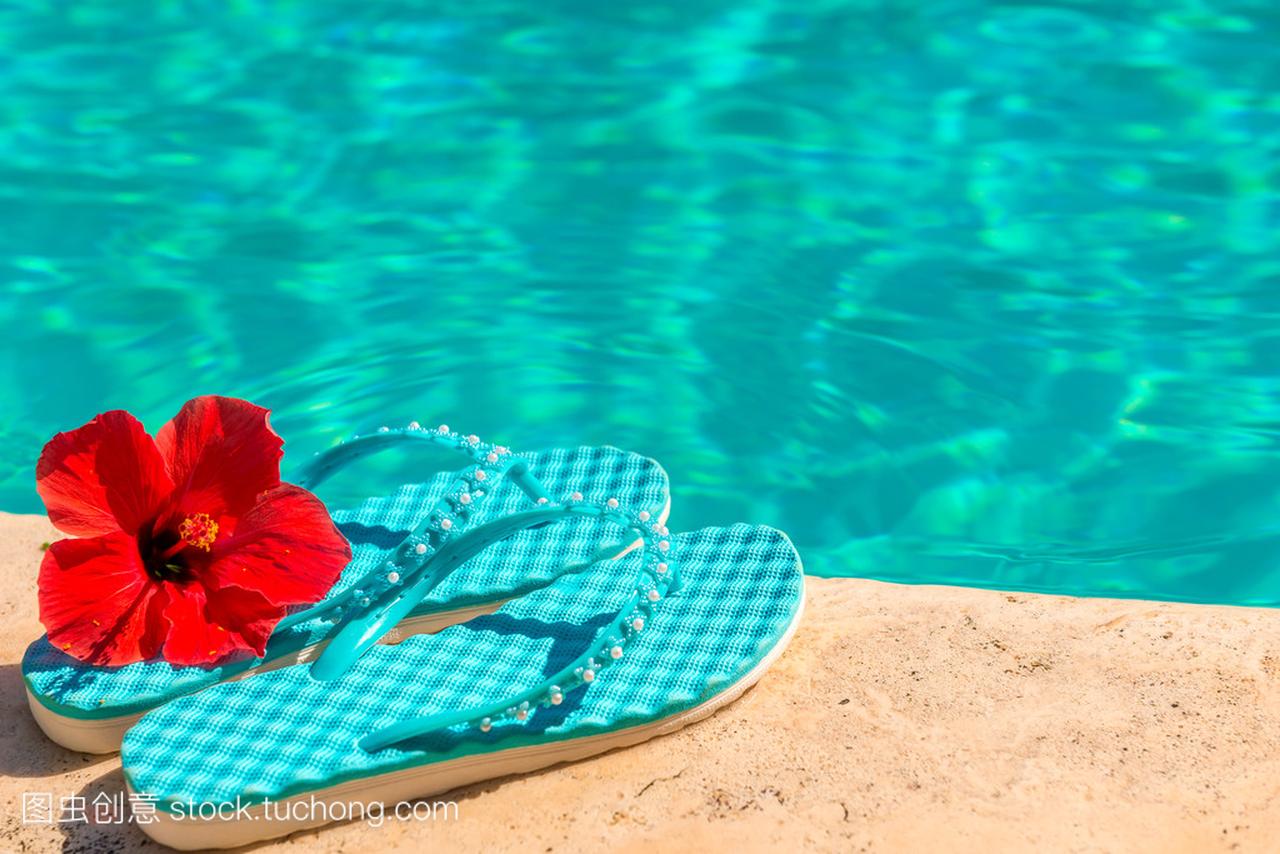 红的花,在游泳池边上拖鞋