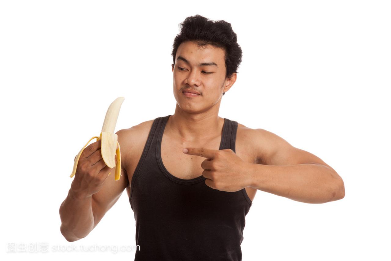 Muscular Asian man point to peeled banana