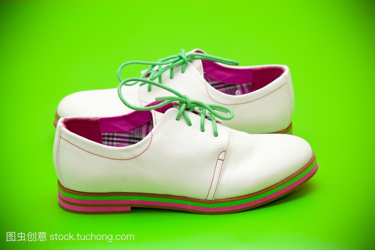 在绿色背景上的绿色鞋带白鞋