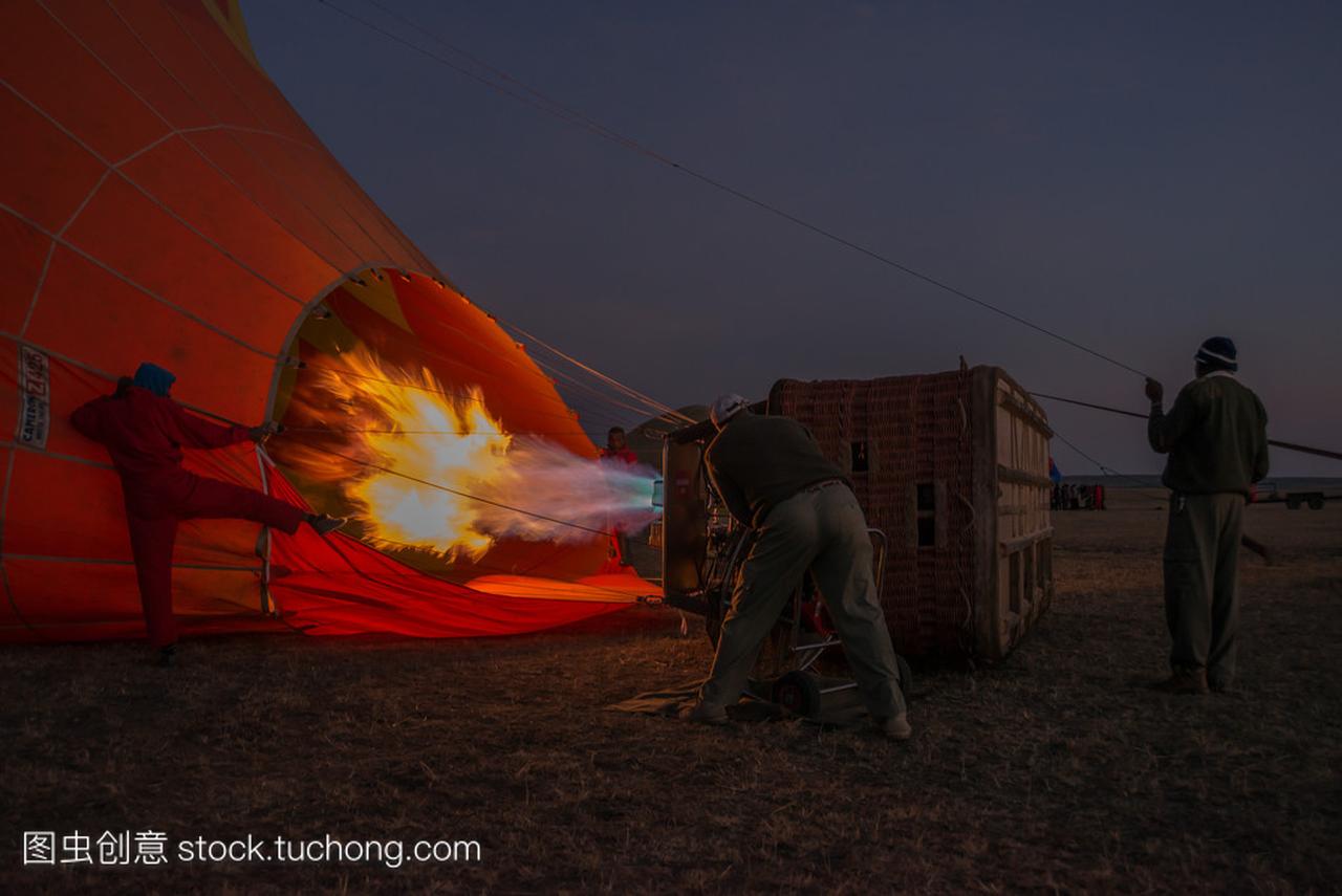 Men before dawn inflating hot air balloon