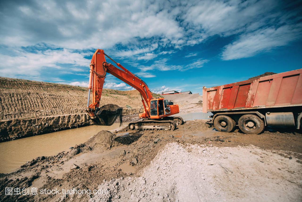 建造业-挖掘机在公路建设工地上工作。在水和