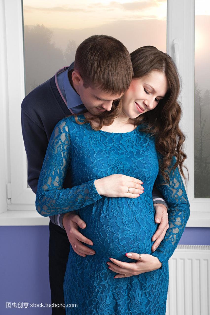丈夫正在抚摸他怀孕的妻子的肚子
