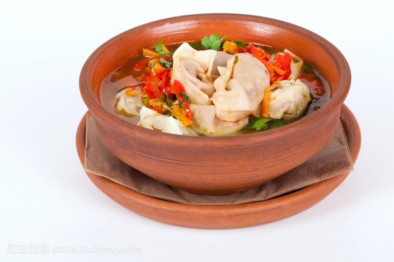 汤饺子和蔬菜泥棕色锅分离白色背景
