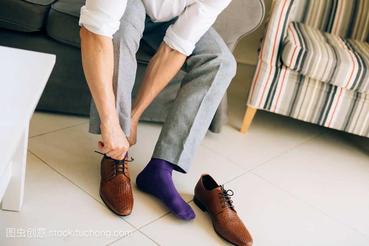 男人在灰色休闲裤和一件紫色的连衣裙袜子棕色