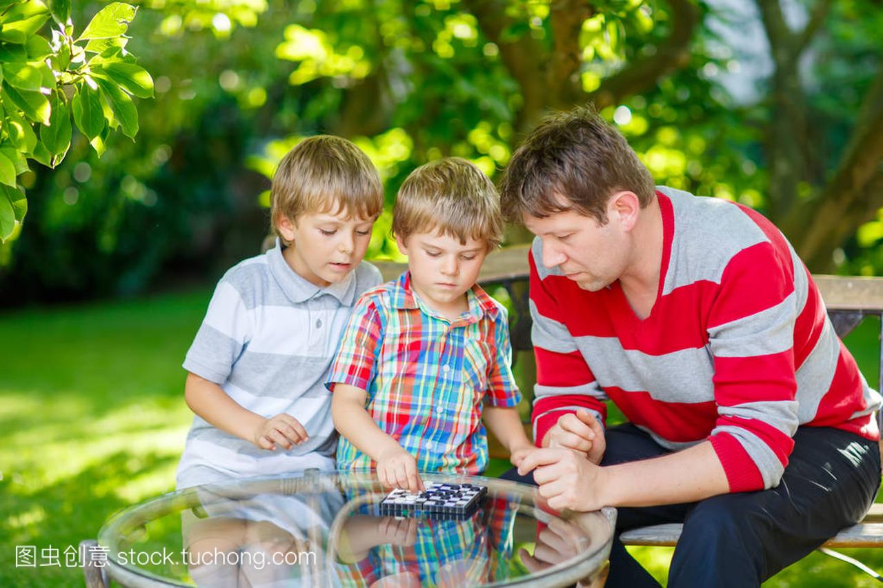 两个小家伙男孩和父亲在一起玩出错西洋跳棋游戏