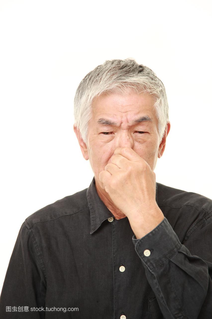 日本老人捏着鼻子因为难闻的气味