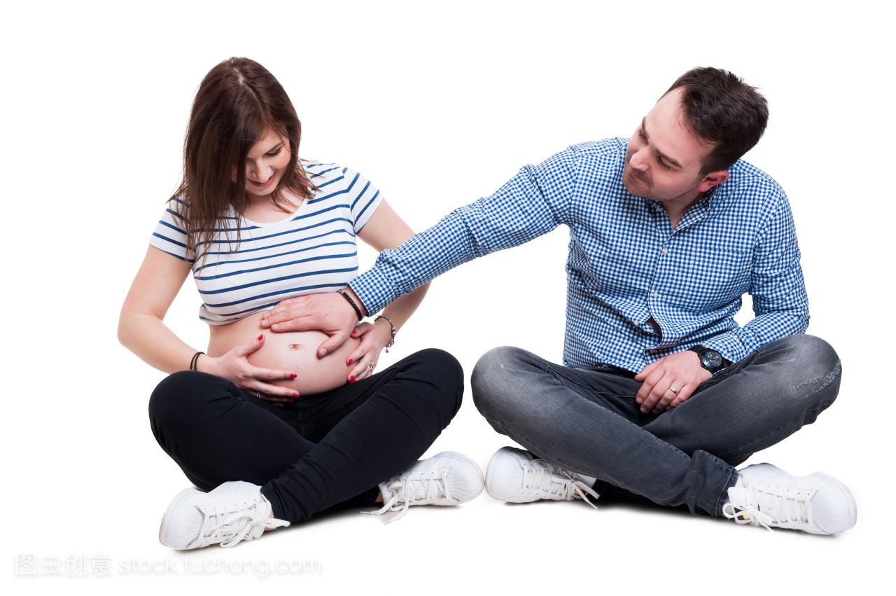 小心的丈夫在他怀孕的妻子肚子上握着的手