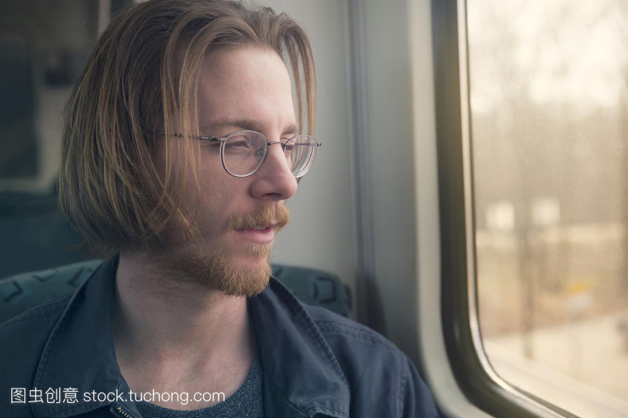 红头发的男人在火车坐着看着