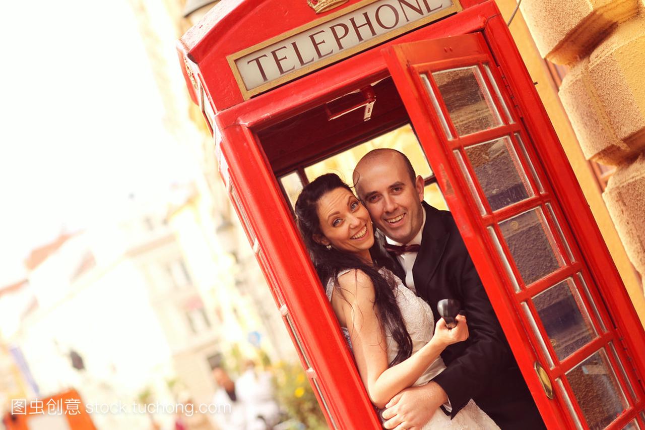 美丽的新娘和新郎在英语电话亭拥抱