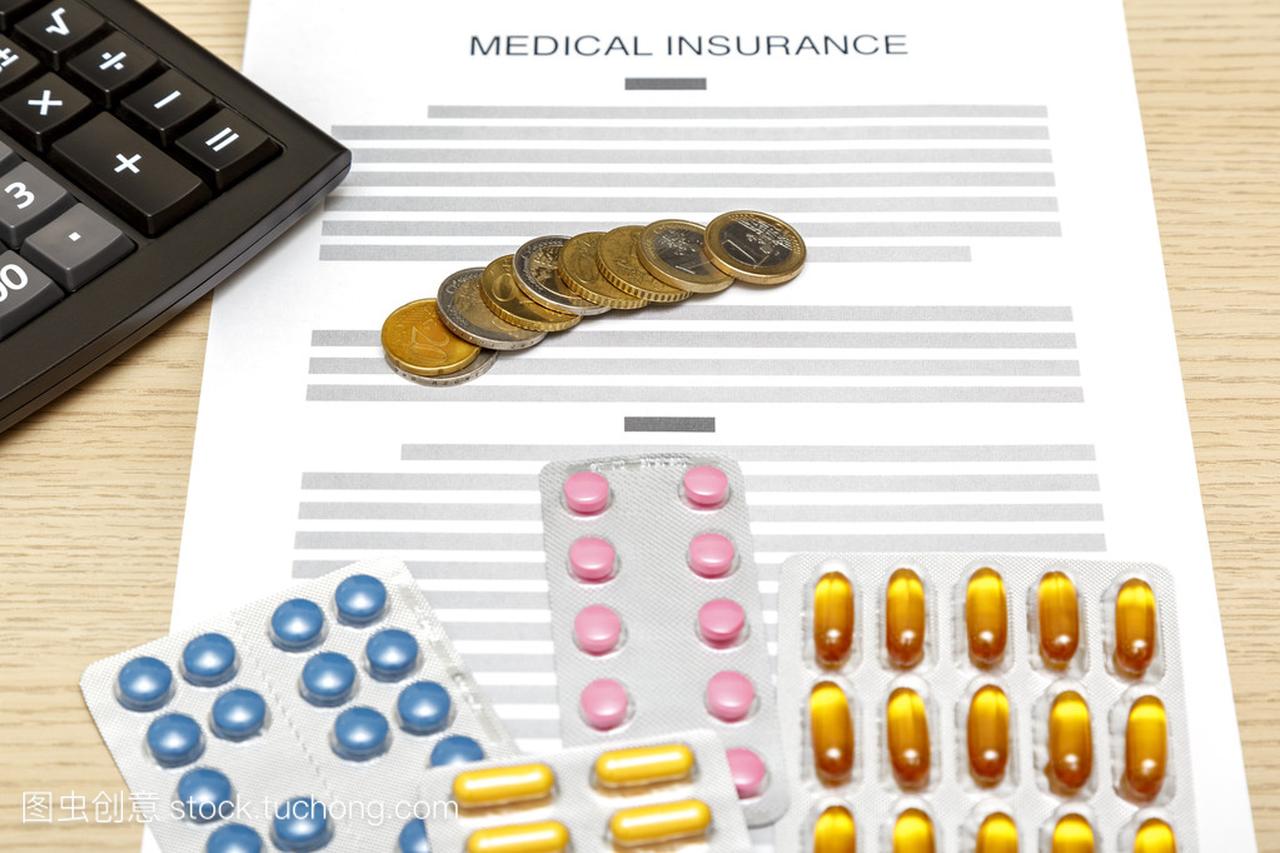硬币、 药片和计算器铺设上医疗保险费的空白