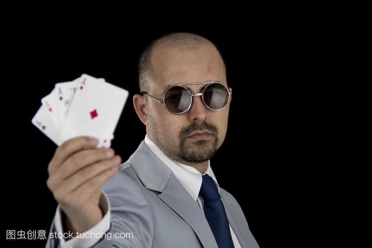 黑色背景上孤立的手里拿着 4 ace 扑克玩扑克牌