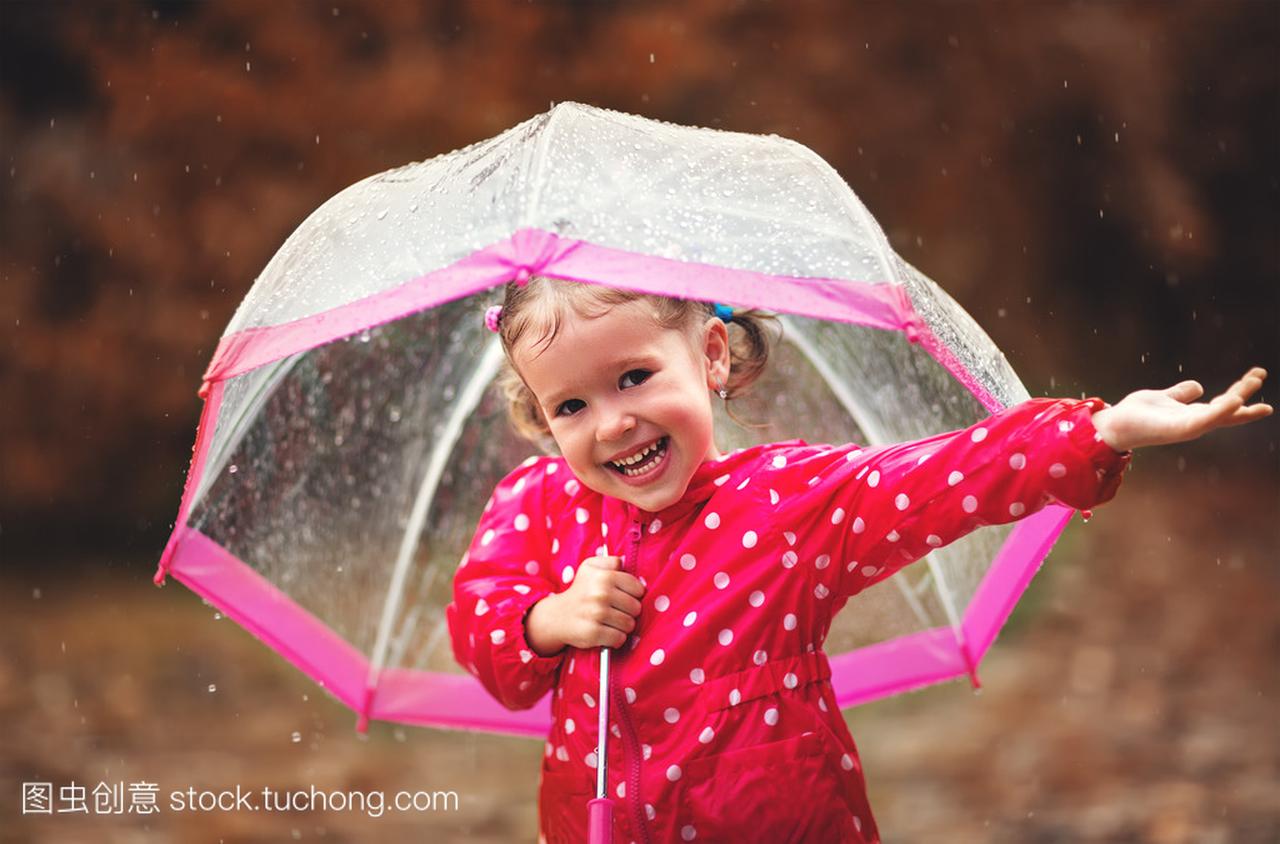 快乐的孩子女孩笑着一把伞在雨中