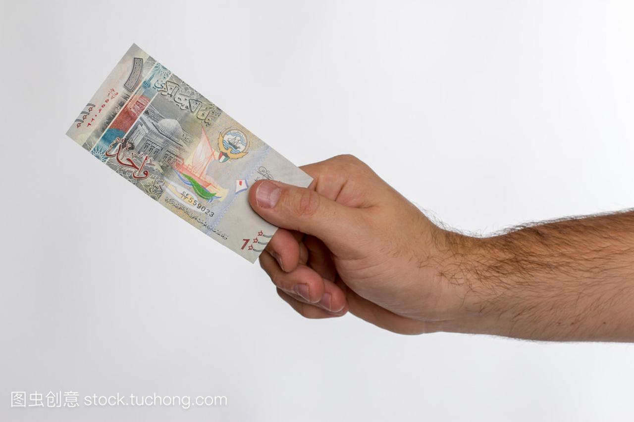 手中的科威特第纳尔钞票。