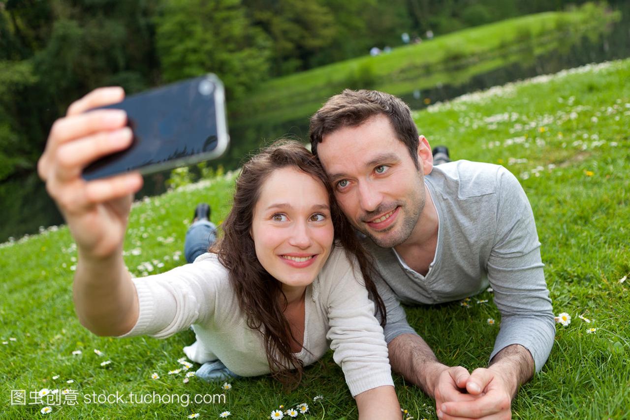 年轻的夫妇在公园里拍拍照的照片
