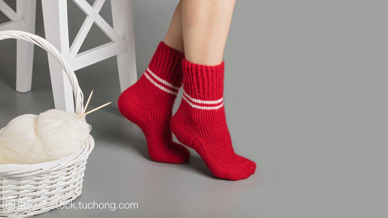 女性在红色针织袜子的脚附近的纱线与 k 篮子