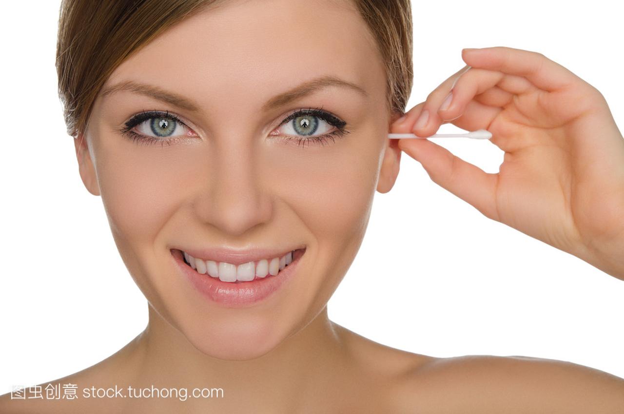Smiling woman cleans ears with cotton sticks