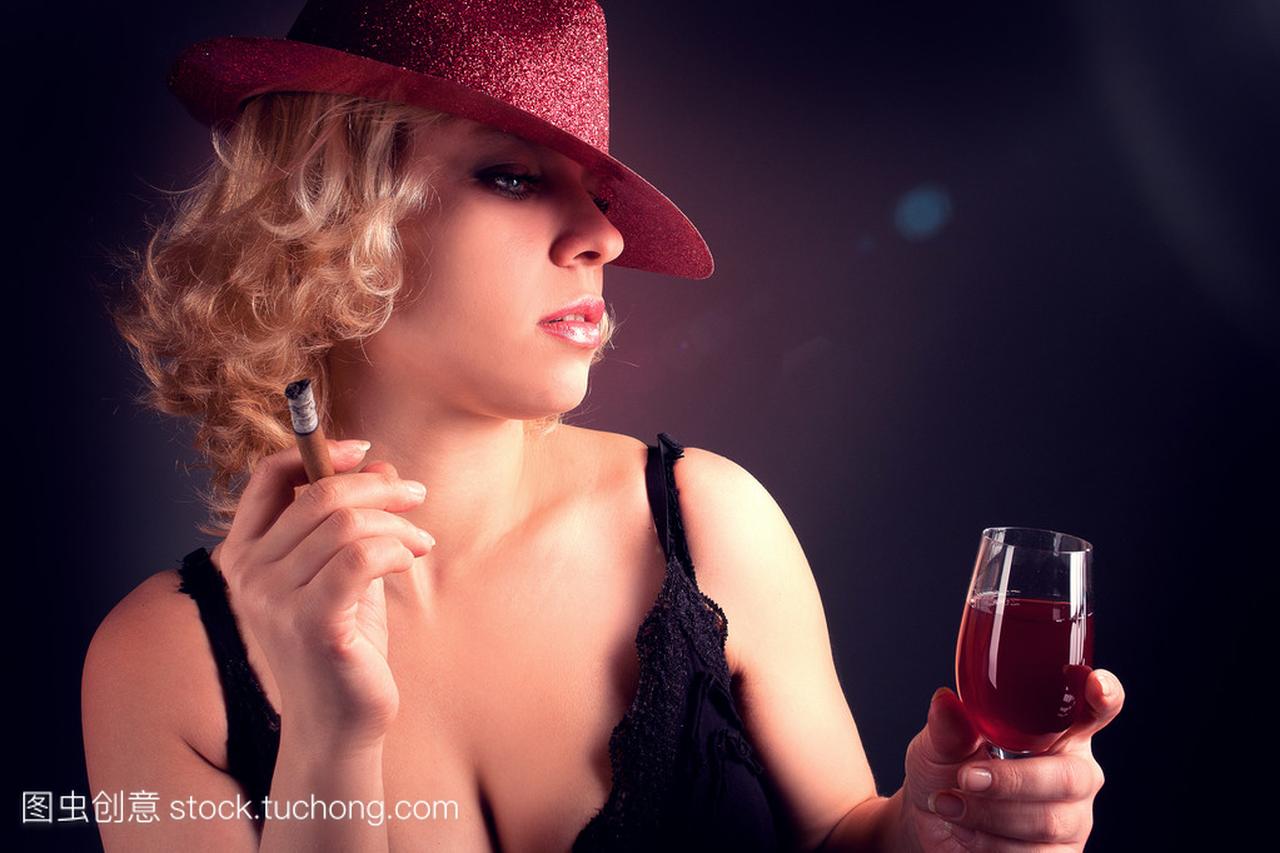 酒红色玻璃与 sigar 中戴着帽子的女人
