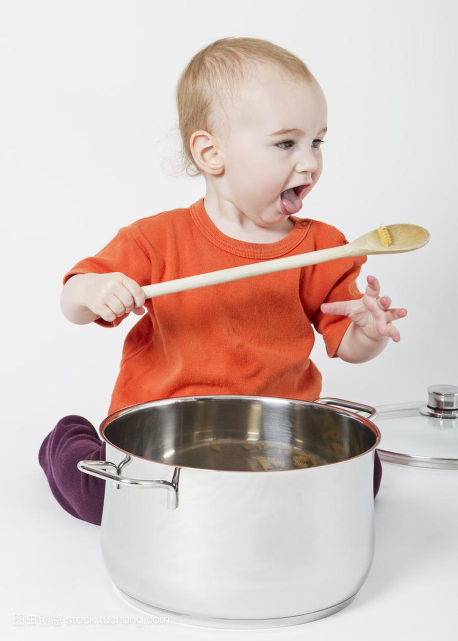 婴儿与大炒菜锅和木勺