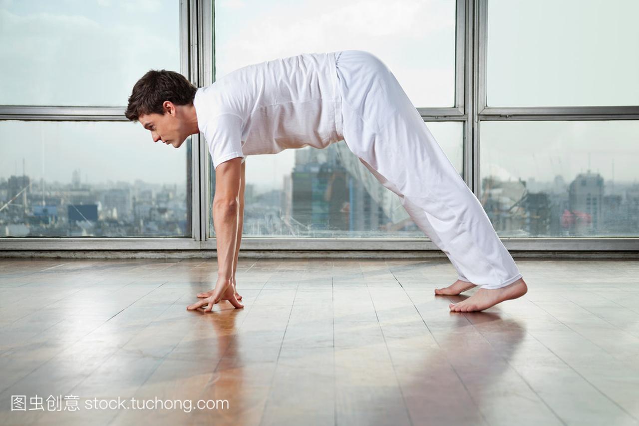 男人练瑜伽在健身房