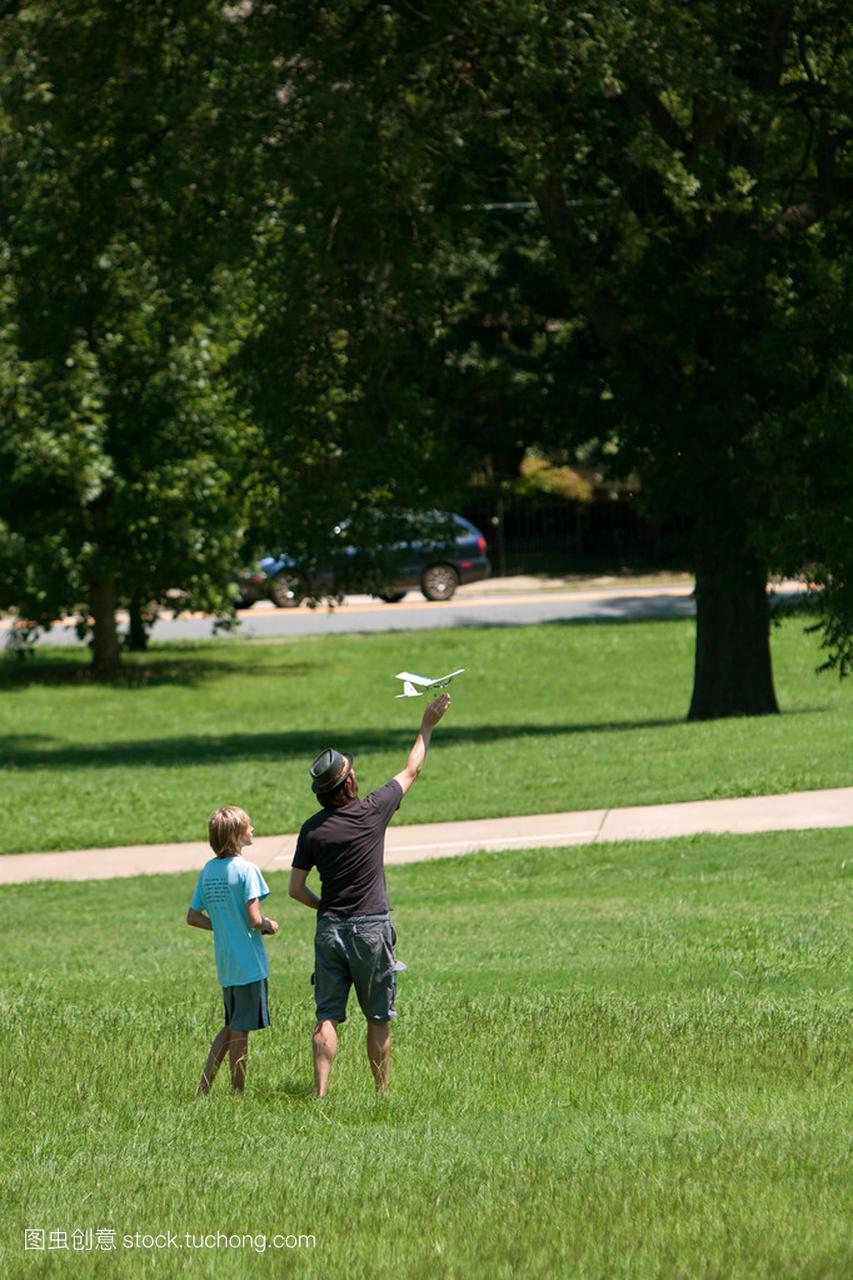 男人和男孩飞模型飞机在公园