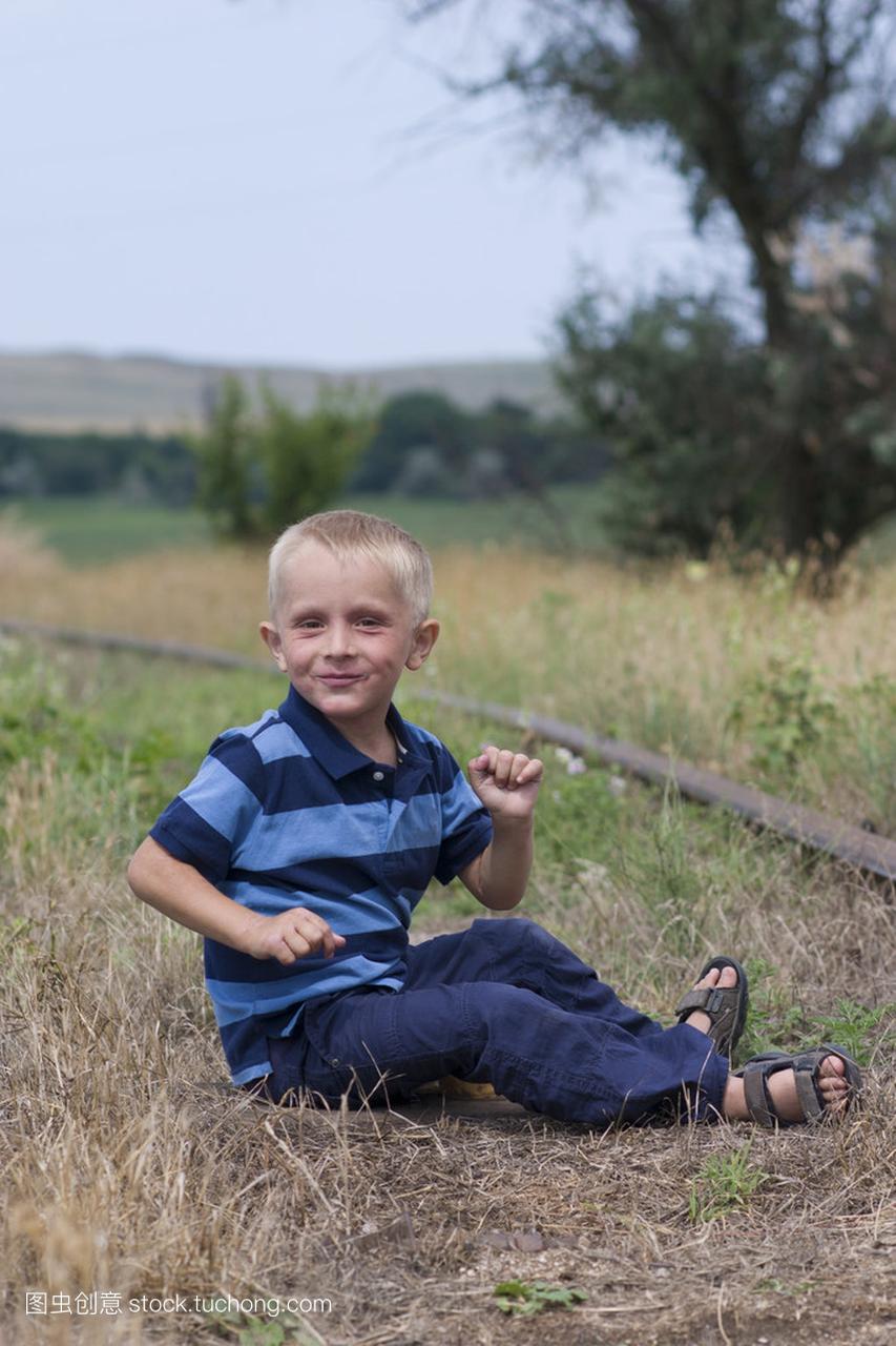 在铁路上玩的可爱小金发男孩
