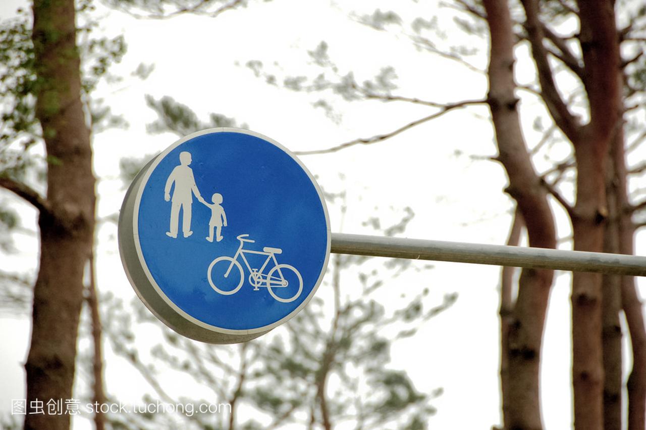 穿蓝色衣服的家庭和自行车交通标志