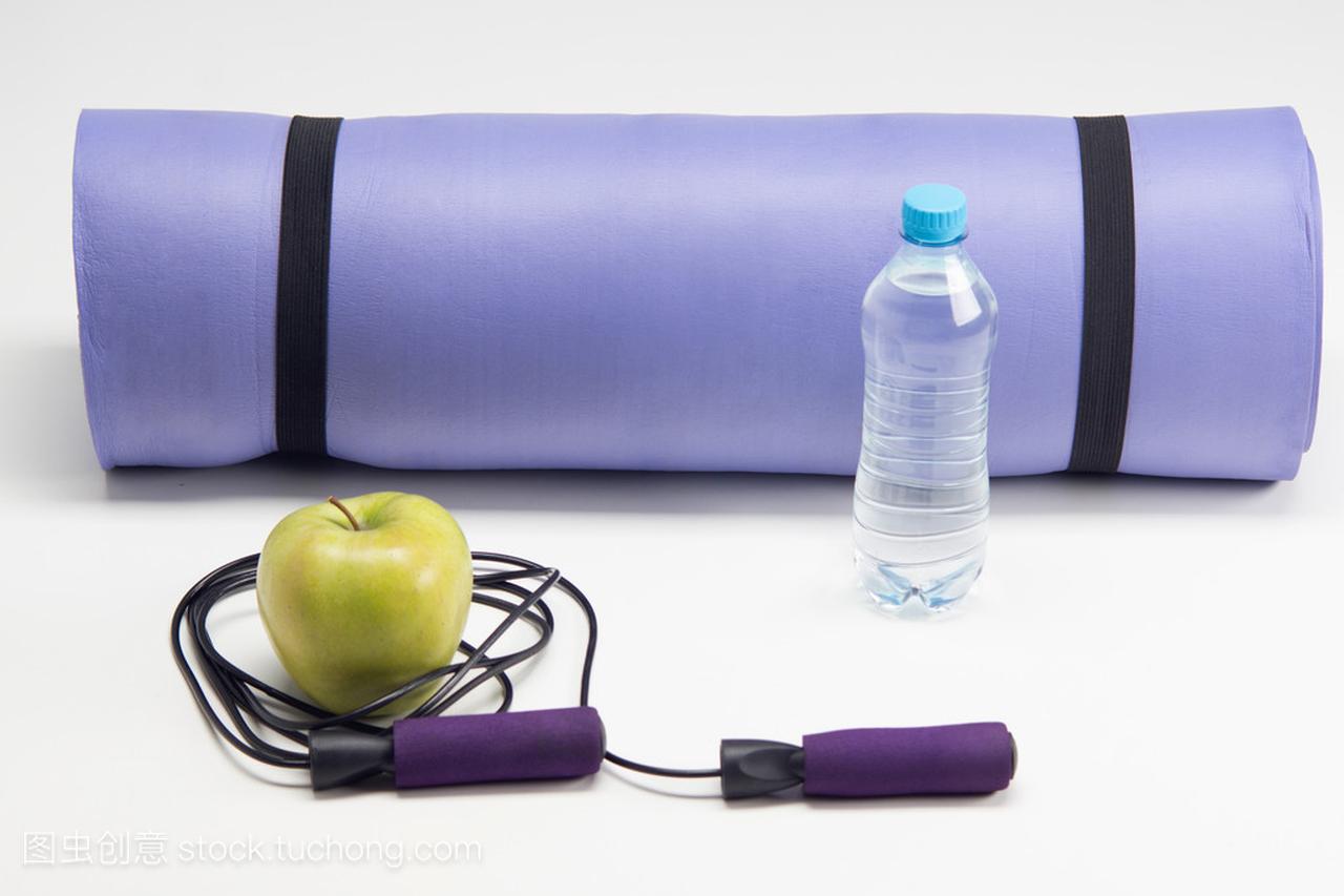 瑜伽垫与跳绳、 苹果和瓶水