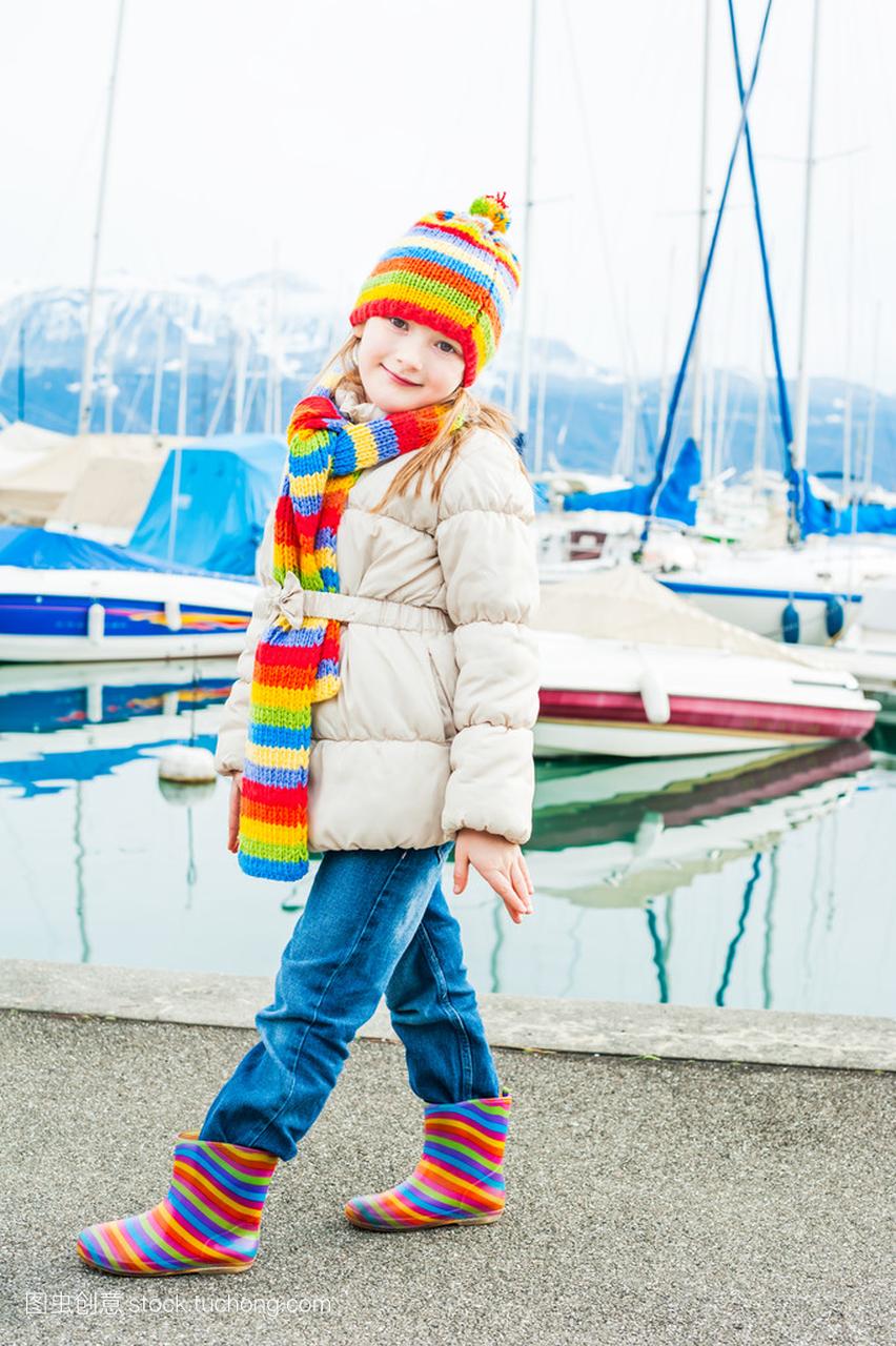 一个可爱的小女孩,穿着夹克、 色彩鲜艳的帽子
