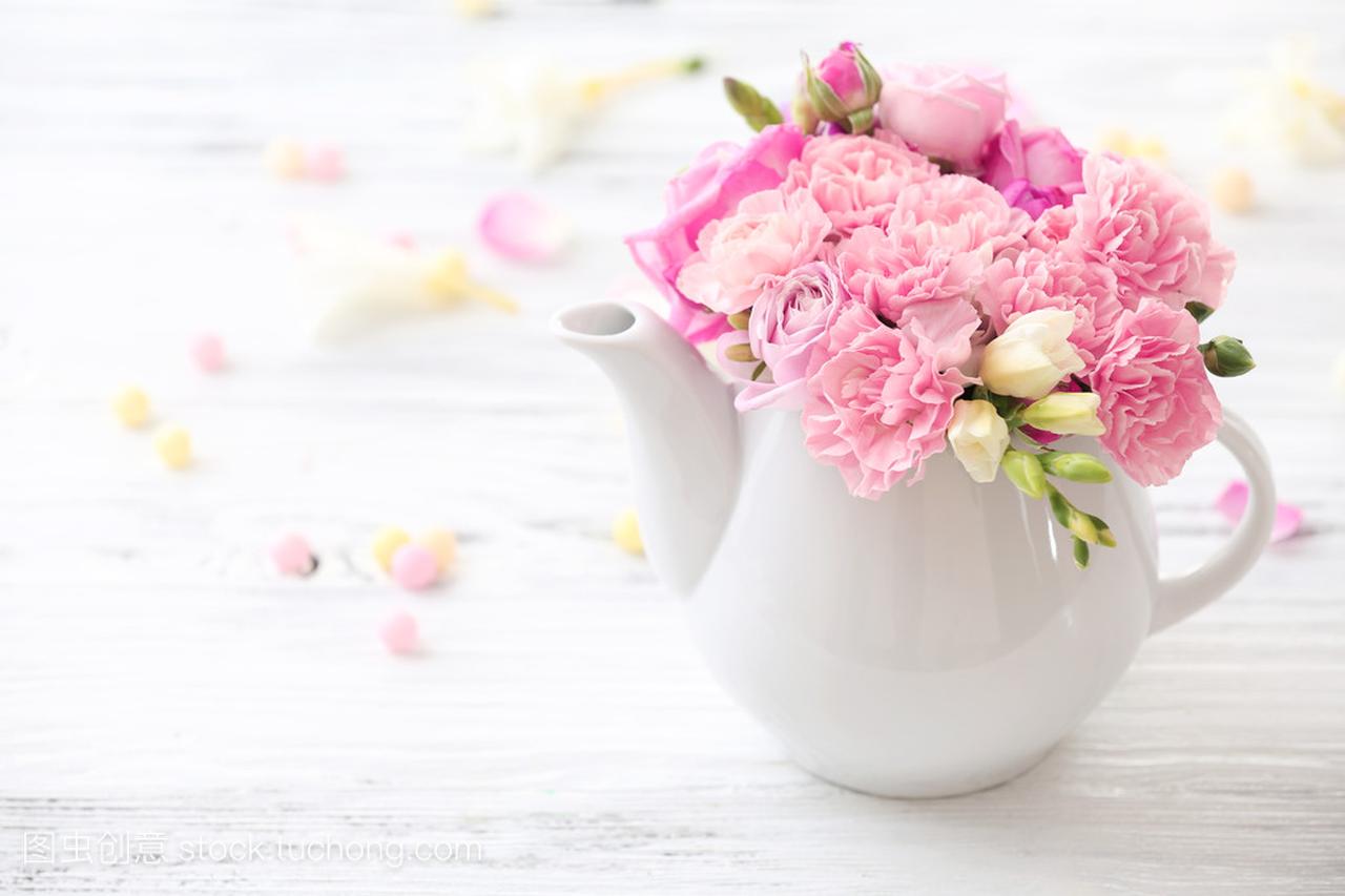 美丽的春天的花朵,在木桌前,特写镜头上的茶壶