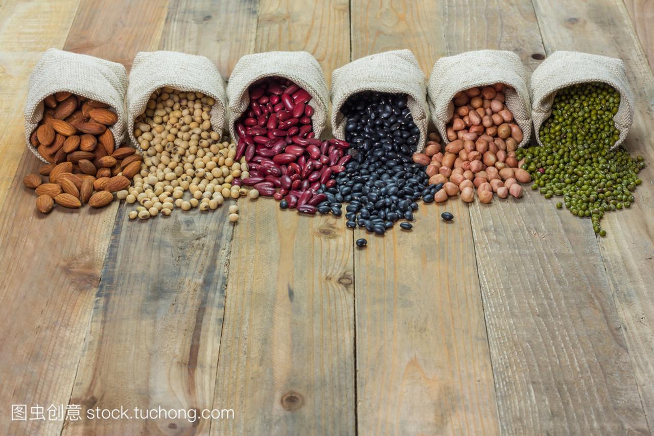 不同种类的豆子散落在木制的背景
