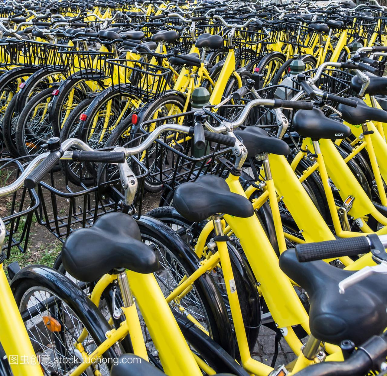 Plenty of yellow bikes parked near a bicycle 