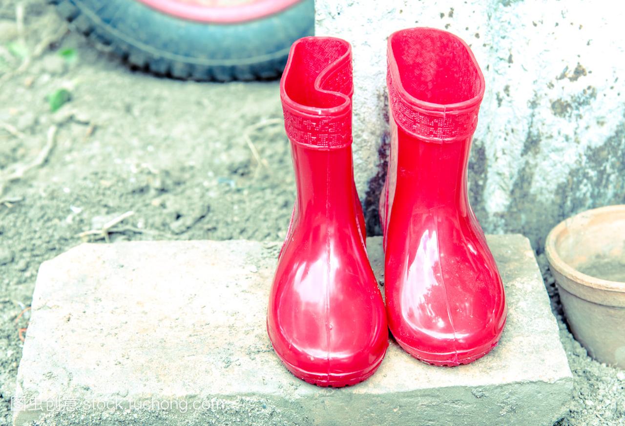 红颜色婴儿靴子。儿童,葡萄酒色花园鞋