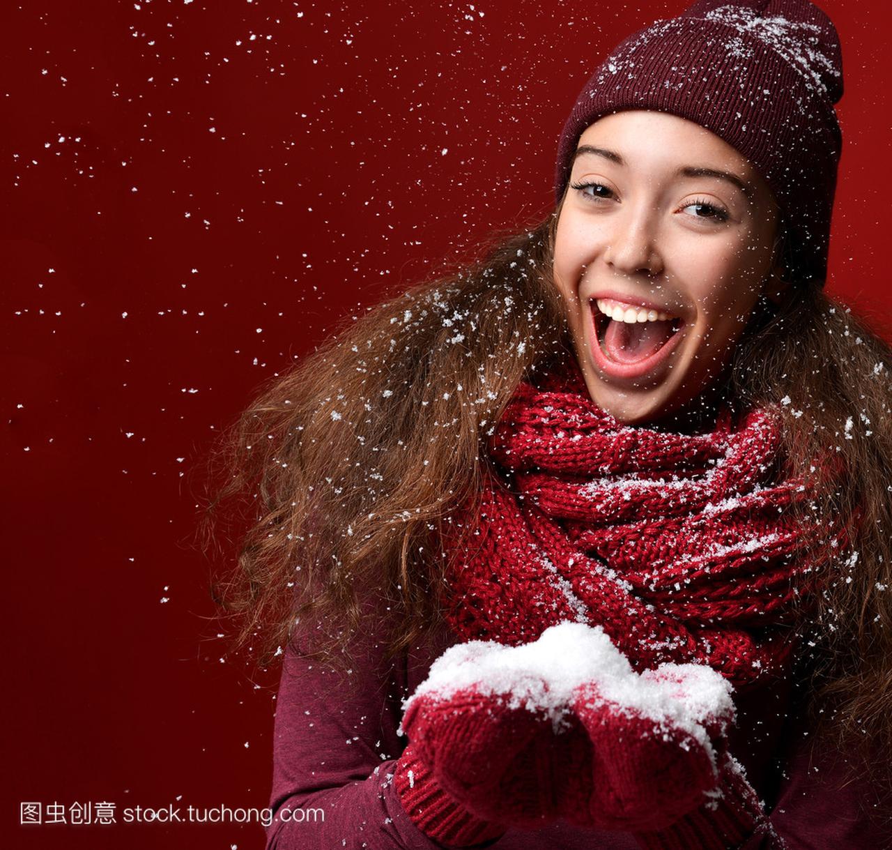 快乐的年轻女孩,在冬天帽子微笑在下雪的天气