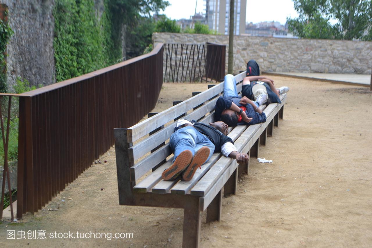 无家可归者睡在一张长椅上